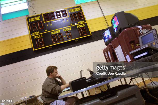 Dana Hill, an associate producer for ABC News, works under the score board in the media center April 12, 2001 at the Crawford, Texas elementary...