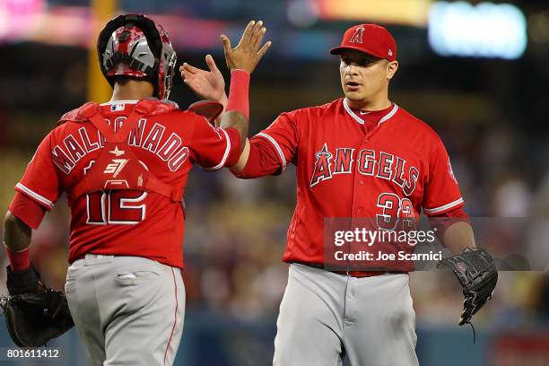 Martin Maldonado of the Los Angeles Angels and David Hernandez of the Los Angeles Angels celebrate their 4-0 win against the Los Angeles Dodgers at...