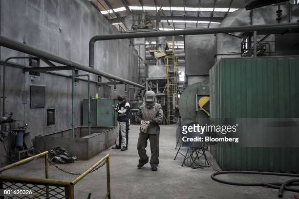 Worker wears protective gear before entering a sand blasting chamber at the Singamas Container Holdings Ltd. Factory in Qidong, China, on Thursday,...