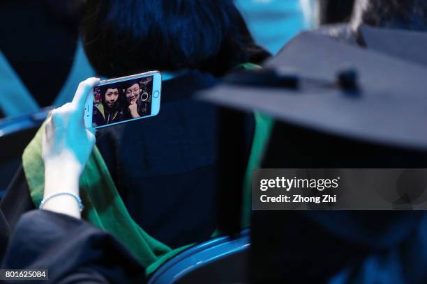 Students takes selfie by her smartphone during the graduation ceremony of Shantou University on June 27, 2017 in Shantou, China.