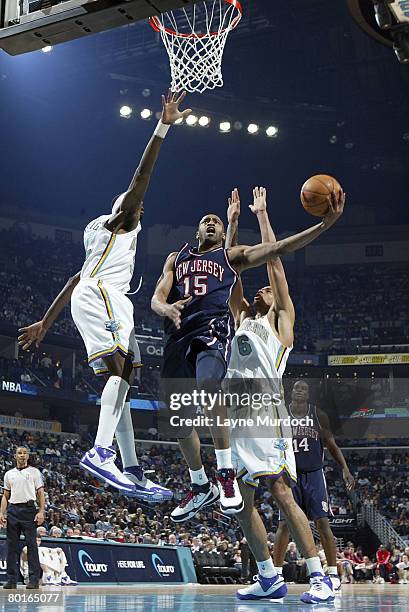 Vince Carter of the New Jersey Nets shoots past Julian Wright and Tyson Chandler of the New Orleans Hornets on March 7, 2008 at the New Orleans Arena...