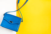 Woman purse on colorful background. Blue and yellow pastel colors, top view