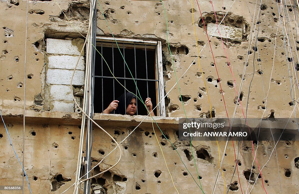 A Palestinian woman looks out the window
