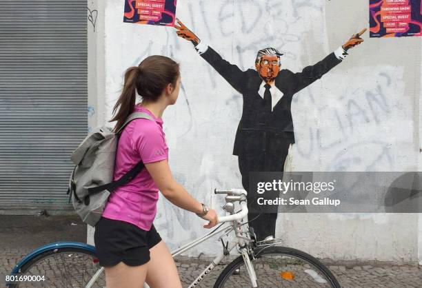 Young woman walks past a street artist's rendition of U.S. President Donald Trump on June 27, 2017 in Berlin, Germany. In a recent poll conducted by...