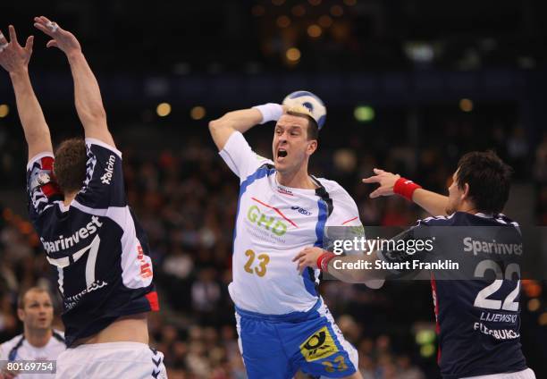 Pascal Hens of Hamburg is challenged by Michael Knudsen and Marcin Lijewski of Flensburg during the EHF champions league handball match between HSV...