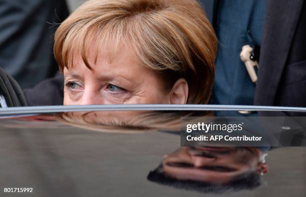 German Chancellor Angela Merkel gets into her car as she leaves the Saint Hedwig Cathedral after attending a memorial service for late former...