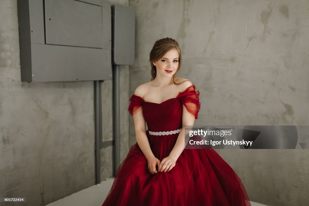 Portrait of woman in  red prom dress  in studio