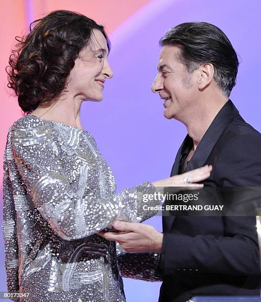 French singer Etienne Daho is congratulated by French actress Anne Brochet after winning the best rock record of the year award during the 23rd...