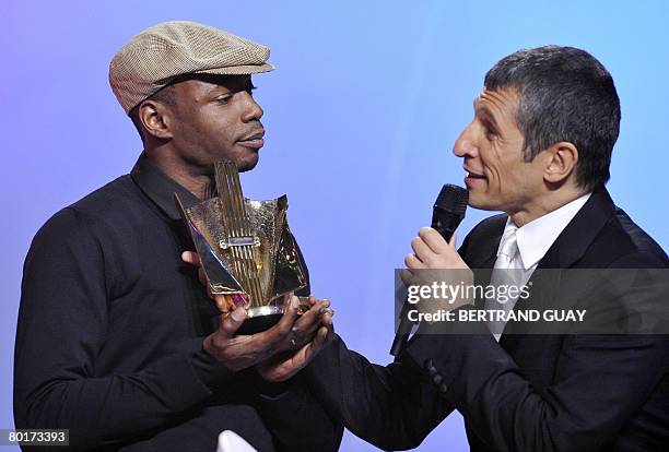 French hip hop singer MC Solaar receives from French TV host Nagui the best urban music record of the year award during the 23rd Victoires de la...