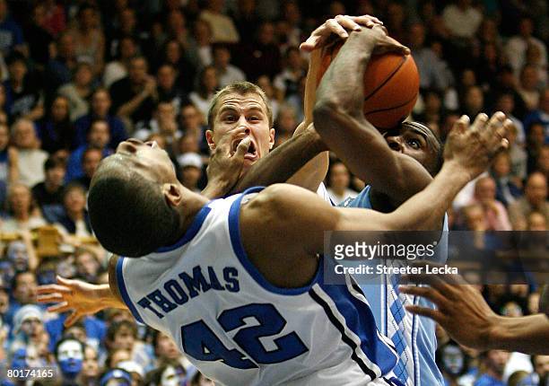 Lance Thomas and teammate Jon Scheyer of the Duke Blue Devils try to stop Ty Lawson of the North Carolina Tar Heels during their game at Cameron...