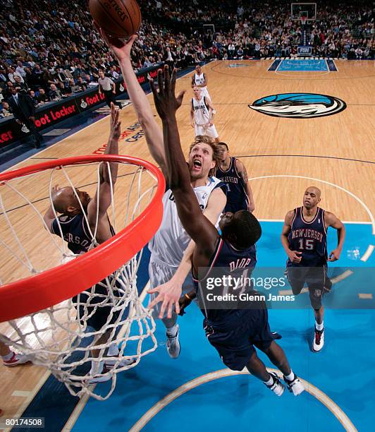 Dirk Nowitzki of the Dallas Mavericks goes up for the layup against DeSagana Diop and Richard Jefferson of the New Jersey Nets at the American...