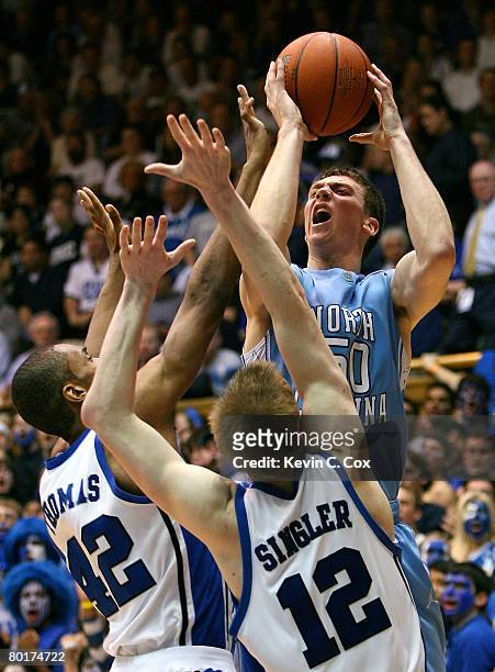 Tyler Hansbrough of the North Carolina Tar Heels shoots over Lance Thomas and Kyle Singler of the Duke Blue Devils during the second half at Cameron...