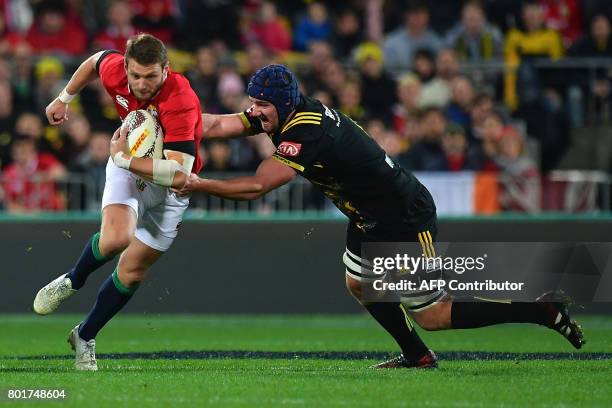 British and Irish Lions player Dan Biggar is tackled by Wellington Hurricanes' Mark Abbott during their rugby union match at Westpac Stadium in...