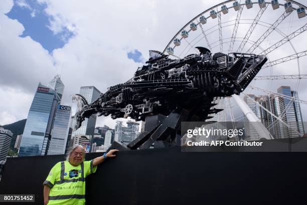 George Wong, Parkview Arts Action founder, poses with Chinese artist Xia Hang's artwork 'To Poseidon' at the 'On Sharks & Humanity' exhibition in...