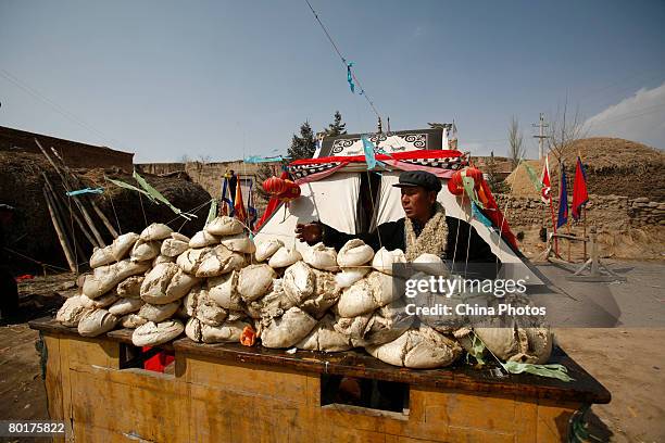 Villager prays in front of offerings of steamed buns during a ceremony to worship the Erlang God at the Dazhuang Village on March 9, 2008 in Huzhu...