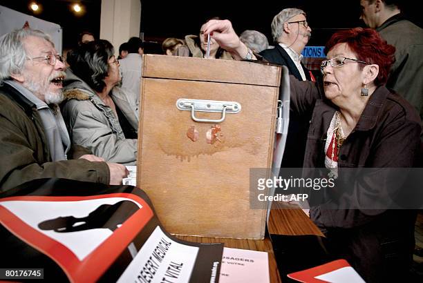 Des personnes glissent le 9 Mars 2008 leur carte d'?lecteur dans une urne install?e ? l'entr?e du bureau de vote de Clamecy, pour que celle ci soit...