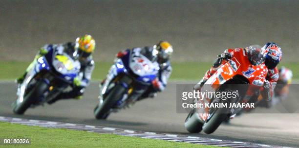 Australian Ducati rider Casey Stoner races the motoGP event with Yamaha rider Jorge Lorenzo of Spain and Yamaha ace Valentino Rossi of Italy at the...