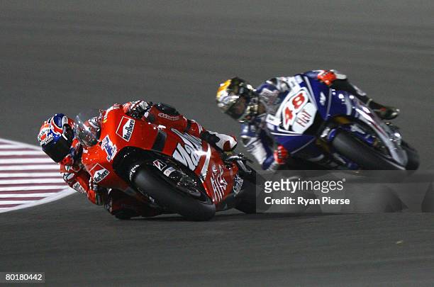 Casey Stoner of Australia and the Ducati Marlboro Team leads Jorge Lorenzo of Spain and Fiat Yamaha Team during the Motorcycle Grand Prix of Qatar,...