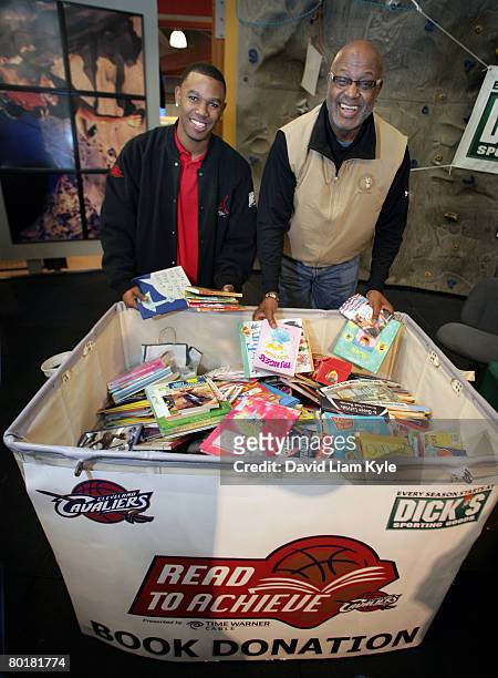 Daniel Gibson of the Cleveland Cavaliers and Cavs Legend Campy Russell show off the large bin of books they collected in exchange for autographs to...