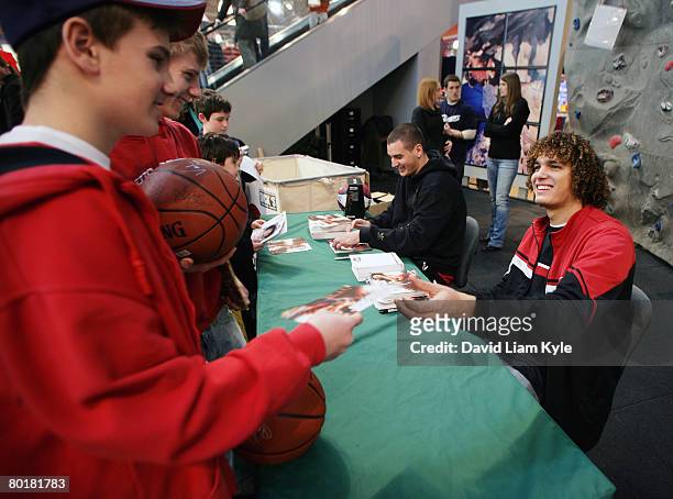 Anderson Varejao of the Cleveland Cavaliers happily exchanges an autograph for a donated children's book to benefit the Cavaliers Read to Achieve...