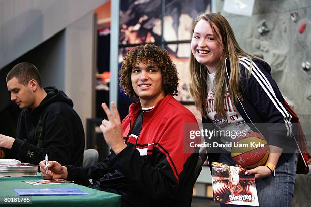 Anderson Varejao of the Cleveland Cavaliers poses with a fan after exchanging an autograph for a donated children's book to benefit the Cavaliers...