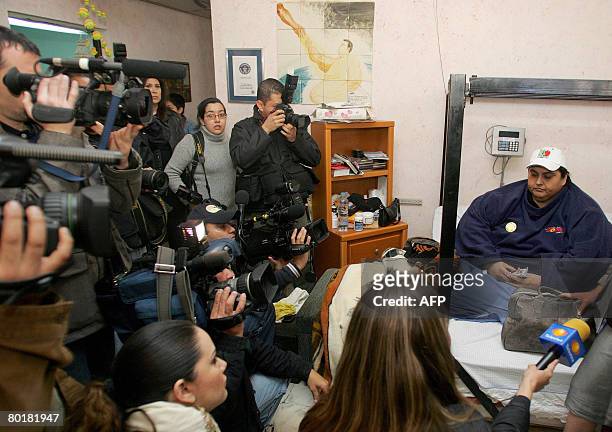 Manuel Uribe , the world's fattest man according to the Guinness Book of Records, is surrounded by the press before leaving for a drive in a truck...