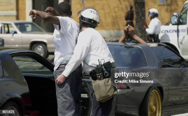 Cincinnati Police officer pats down the passenger of a car police pulled over after the funeral of Timothy Thomas April 14, 2001 in Cincinnati, OH. A...