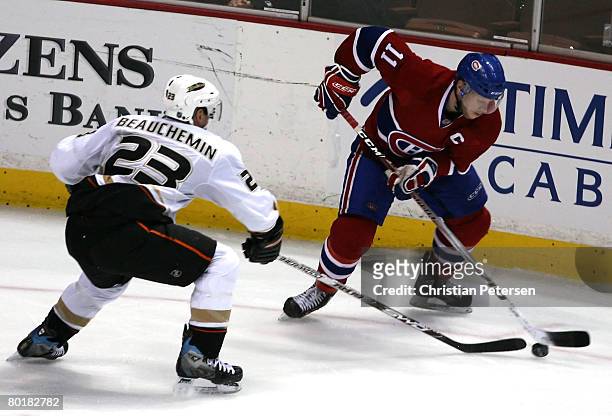 Saku Koivu of the Montreal Canadiens handles the puck under pressure from Francois Beauchemin of the Anaheim Ducks during the NHL game at Honda...