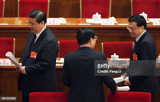 Politburo members of Xi Jinping, He Guoqiang and Li Keqiang leave after the third plenary session of the National People's Congress, or parliament,...