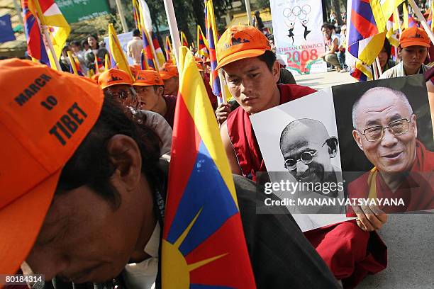 Tibetan Buddhist monks in-exile and part of core marchers group hold portraits of the Indian Father of the nation Mahatma Gandhi and His holiness the...