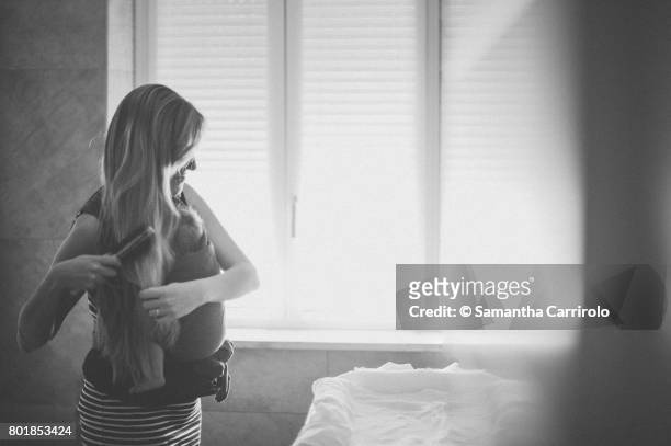 madre con bambino in fascia. vita domestica. - vita domestica fotografías e imágenes de stock