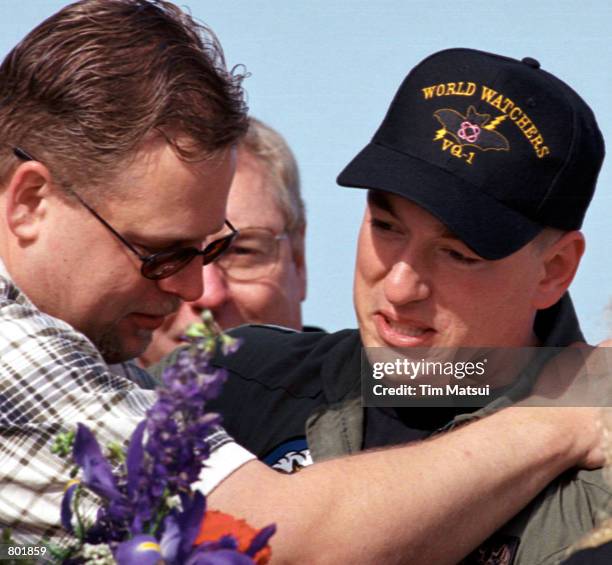 Lt. Shane Osborn, right, the pilot of the US Navy EP-3 spy plane, hugs a family member as the crew of the surveillance plane who were detained in...