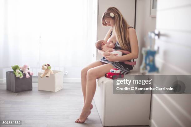 madre che allatta. vita domestica. - abbracciare una persona stock pictures, royalty-free photos & images