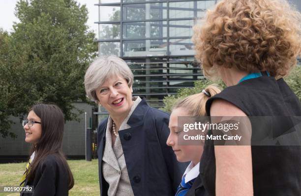 Prime Minister Theresa May walks with pupils Miya Herbert Katie Davies and head teacher Dr Helen Holman as she arrives for a session for teachers...