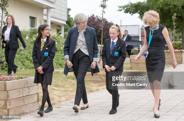 Prime Minister Theresa May walks with pupils Miya Herbert Katie Davies and head teacher Dr Helen Holman as she arrives for a session for teachers...