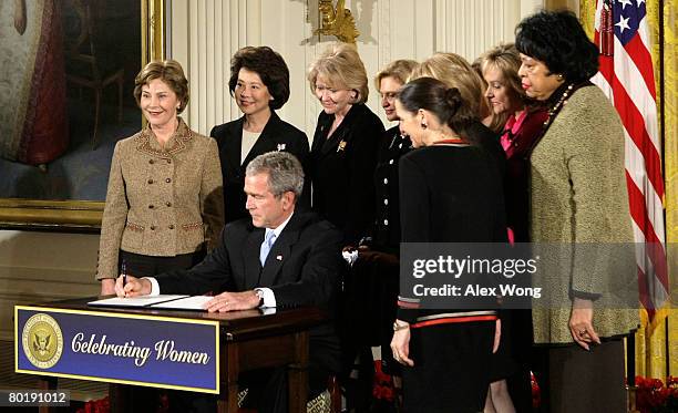 Surrounded by cabinet and congressional members, first lady Laura, Secretary of Labor Elaine Chao, Secretary of Transportation Mary Peters, Rep....