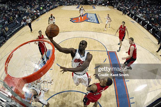 Emeka Okafor of the Charlotte Bobcats shoots a layup against Jamario Moon of the Toronto Raptors during the game at the Charlotte Bobcats Arena on...