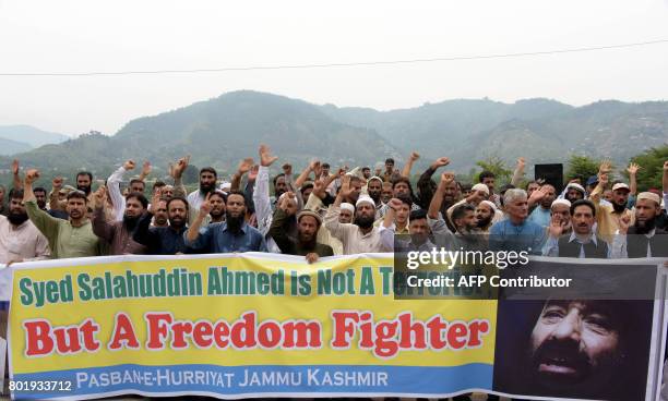 Pakistani Kashmiri activists carry a banner as they shout slogans during a protest against United States' sanctions on Syed Salahuddin, supreme...