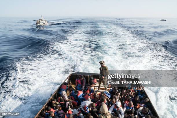 Libyan coast guardsman stands on a boat during the rescue of 147 illegal immigrants attempting to reach Europe off the coastal town of Zawiyah, 45...