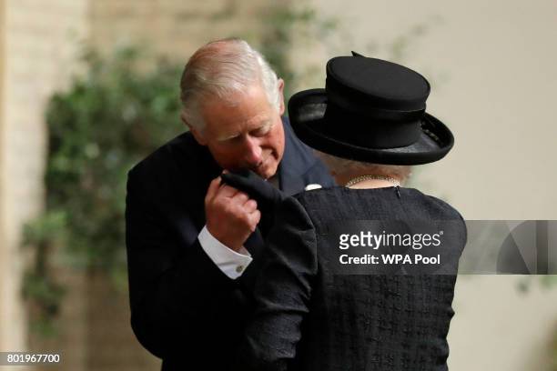 Queen Elizabeth II is greeted by her son Prince Charles, Prince of Wales as she arrives at the funeral service of Patricia Knatchbull, Countess...