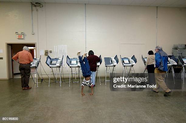 Joseph Rupert finds an interesting way to pass the time while his mother, Jackie Rupert, both of Meridian, Mississippi, votes in Mississippi's Super...