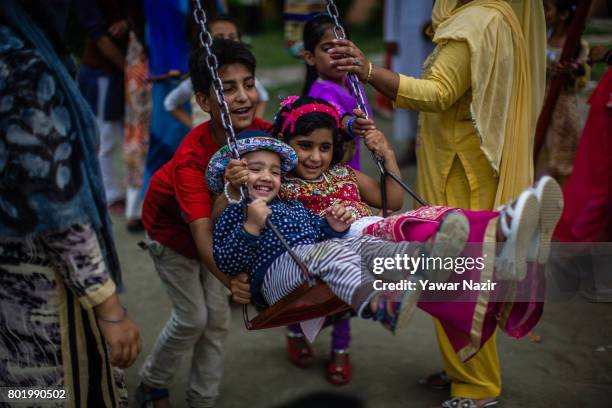 Kashmiri children enjoy the amusement rides on the second day of the Eid-Al-Fitr, a Muslim festival, on June 27, 2017 in Srinagar, the summer capital...