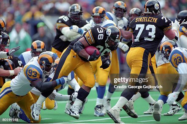 Defensive lineman Kevin Carter of the St. Louis Rams tackles running back Jerome Bettis of the Pittsburgh Steelers as offensive lineman Justin...