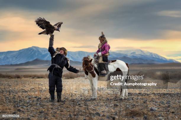 the eagle hunter's siblings coaching their eagle. - bayan olgiy stockfoto's en -beelden