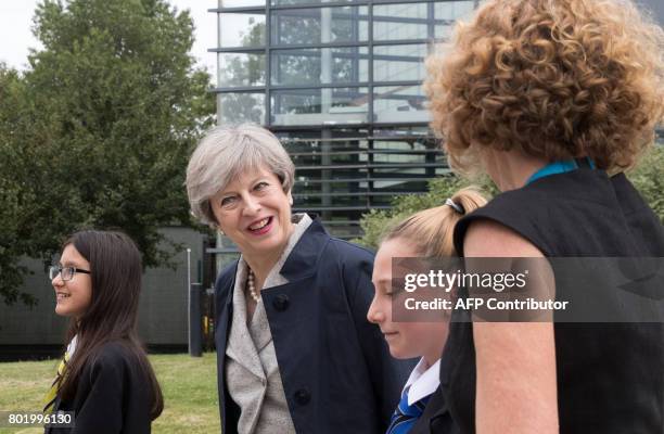 Britain's Prime Minister Theresa May walks with pupils Miya Herbert,, Katie Davies and head teacher Dr Helen Holman on her arrival to attend a...