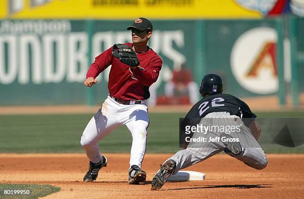 Chris Burke of the Arizona Diamondbacks looks to tag out Marcus Giles of the Colorado Rockies during a spring training game at Tucson Electric Park...
