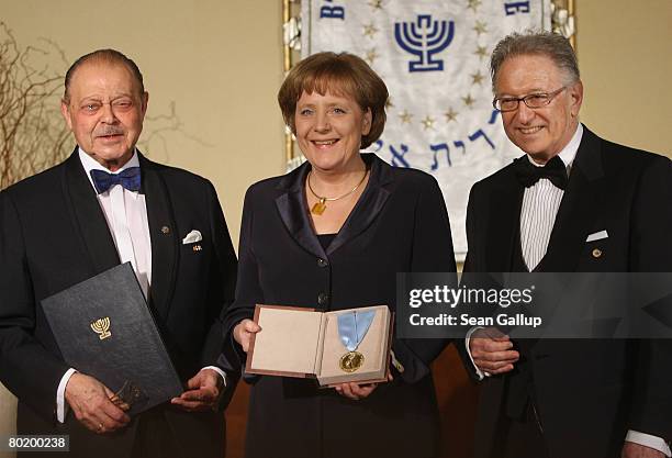 German Chancellor Angela Merkel holds her Gold Medal from B'nai B'rith while standing with B'nai B'rith Europe Honourary President Joseph Domberger...