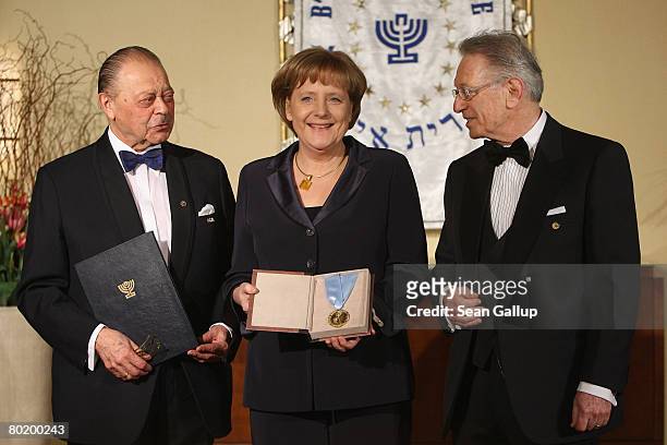 German Chancellor Angela Merkel holds her Gold Medal from B'nai B'rith while standing with B'nai B'rith Europe Honourary President Joseph Domberger...