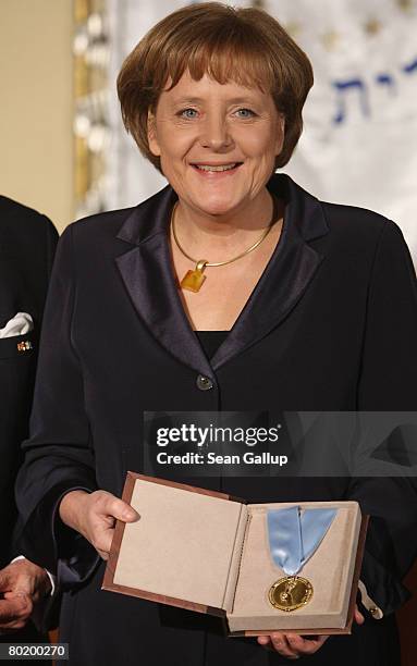 German Chancellor Angela Merkel holds her Gold Medal from B'nai B'rith at the B'nai B'rith Europe Award of Merit at the Marriot hotel on March 11,...
