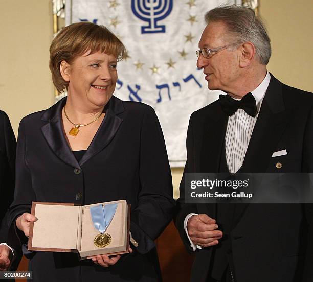 German Chancellor Angela Merkel holds her Gold Medal from B'nai B'rith while standing with B'nai B'rith Europe President Reinold Simon at the B'nai...